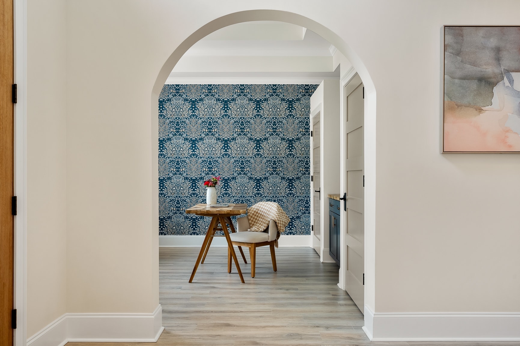 Bonus room with designer wallpaper and arched doorway