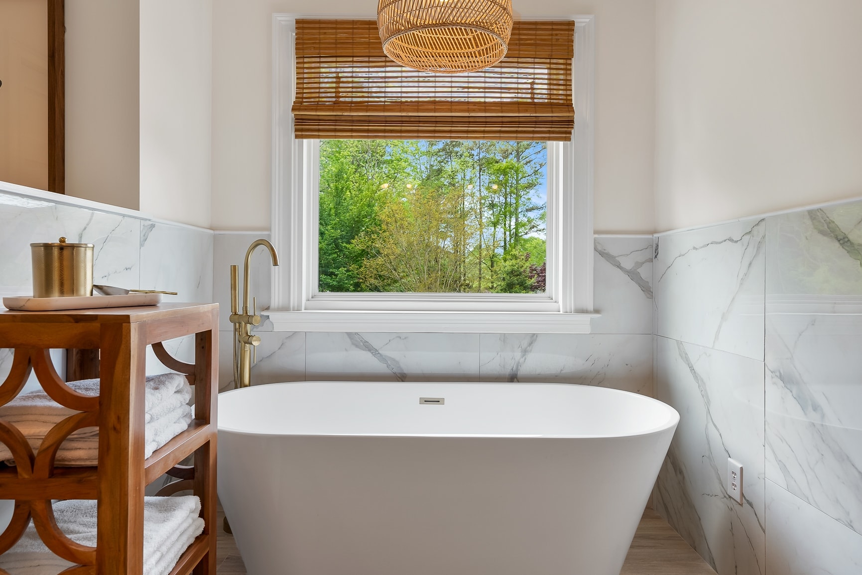 Spa bathroom with freestanding soaking tub and marble surround