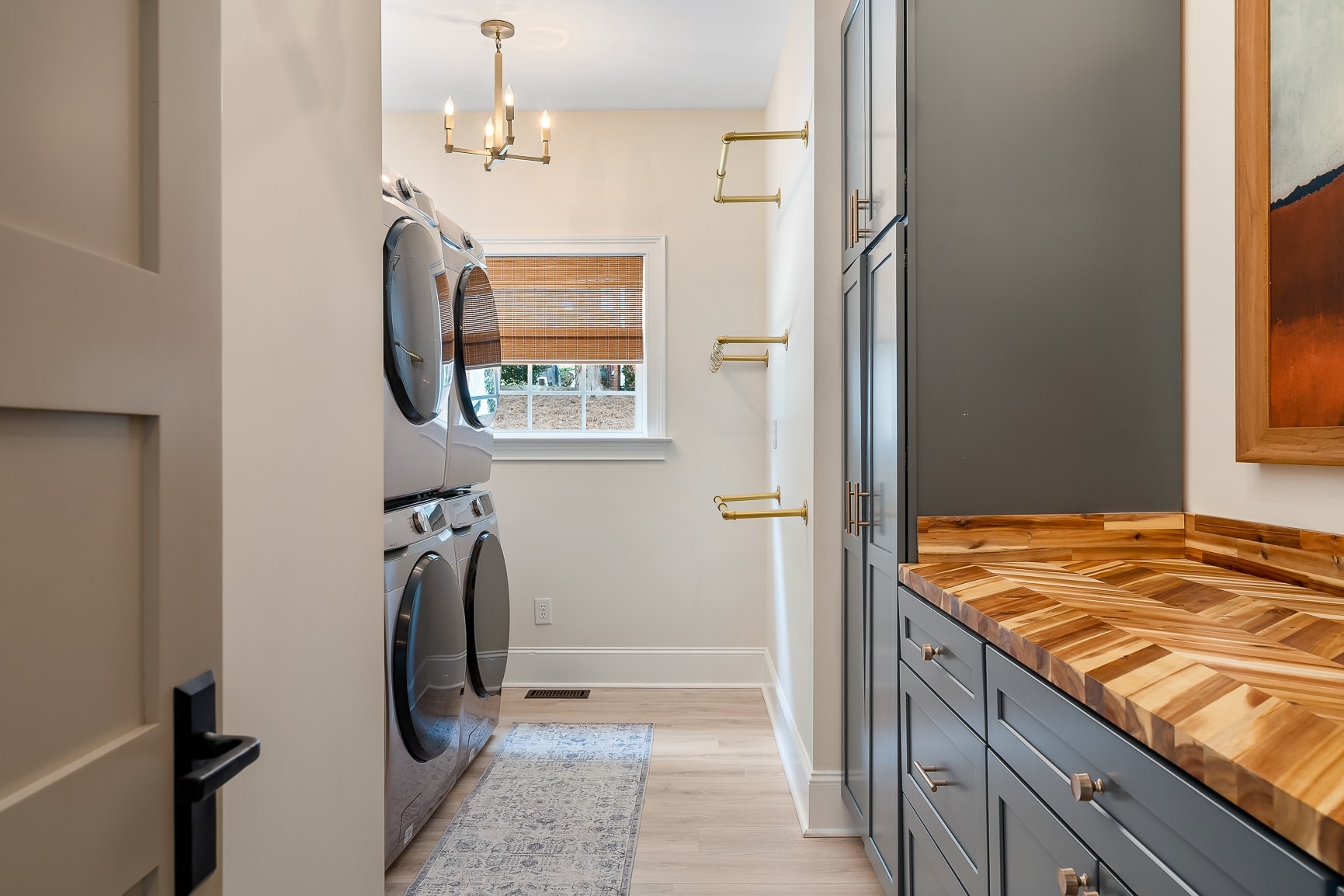 Designer laundry room with custom cabinetry and brass fixtures